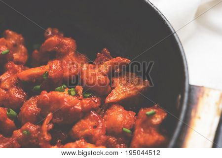 Gobi Manchurian dry - Popular street food of India made of cauliflower florets in a frying pan, selective focus