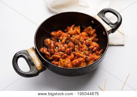 Gobi Manchurian dry - Popular street food of India made of cauliflower florets in a frying pan, selective focus