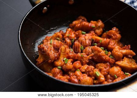 Gobi Manchurian dry - Popular street food of India made of cauliflower florets in a frying pan, selective focus