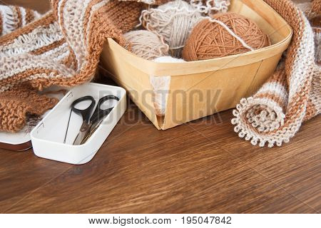 Balls of wool and knitting on the wooden background