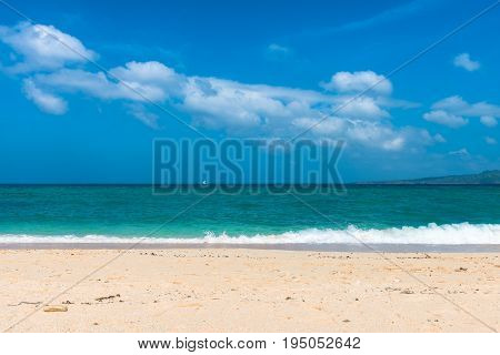 BORACAY WESTERN VISAYAS PHILIPPINES - JANUARY 14 2015: Horizontal picture of the green and blue water of Puka Beach in a sunny day with some white clouds.