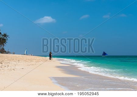 BORACAY WESTERN VISAYAS PHILIPPINES - JANUARY 14 2015: Two women and one boat in the tropical Puka Beach Boracay.