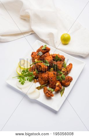 Chicken 65 - spicy deep fried Bar appetizer or quick snack from India in a bowl or plate over white background, selective focus