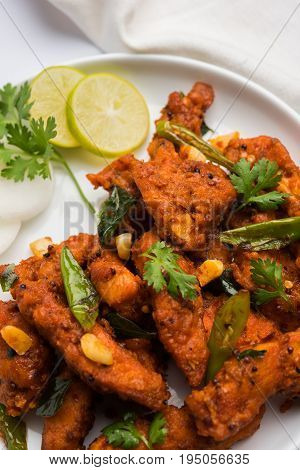 Chicken 65 - spicy deep fried Bar appetizer or quick snack from India in a bowl or plate over white background, selective focus