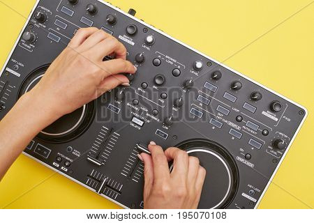 Flat lay of mixing board lying catty-corner. Woman hands touching electronic device, mid shot