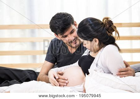 Man Touching Pregnant Woman With Happy Emotion Together At Home.
