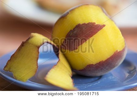 fresh peach peeled on a colored dish