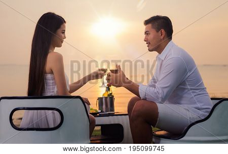 Asian couple in romantic dinner with sea beach and sunset in Thialand island. love valentine summer and honymoon concept.