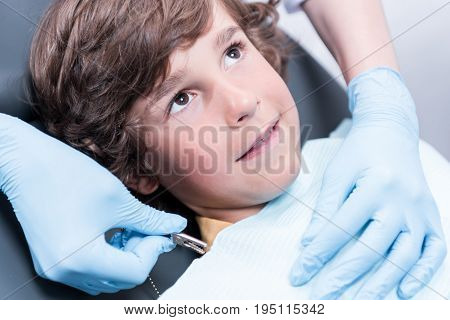 Dentist Preparing Little Boy For Examining Teeth In Dentist Office