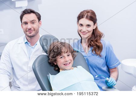 Dentists Preparing Little Boy For Examining Teeth In Dental Clinic