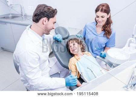 Dentists Preparing Little Boy For Examining Teeth In Dental Hospital
