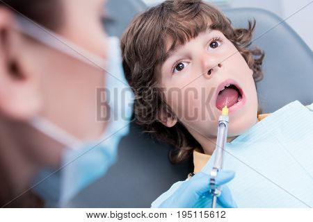 partial view of dentist giving injection on anesthesia to patient in dentist office