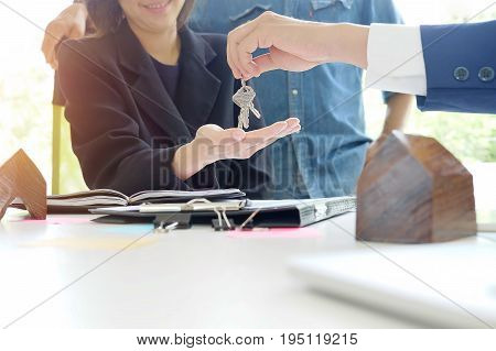 Buying a house conceptCouple siting on a sale house office with a business talk for sale vintage tone.