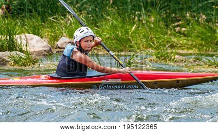 Village Myhia Mykolayiv region South Bug River Ukraine - July 9 2017: A teenager trains in the art of kayaking. Boat boats on rough river rapids. The child is skillfully engaged in rafting.