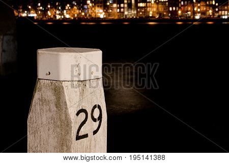 Port pole with a night life cityview of rotterdam with reflection in the water