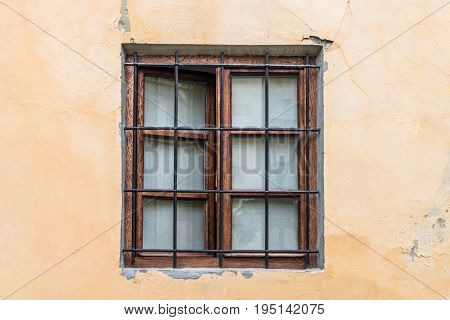 Front view vintage lattice window on a beige wall with scratches