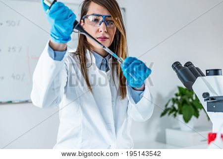 Laboratory Technician With Micro Pipette, One Woman Only, Toned Image
