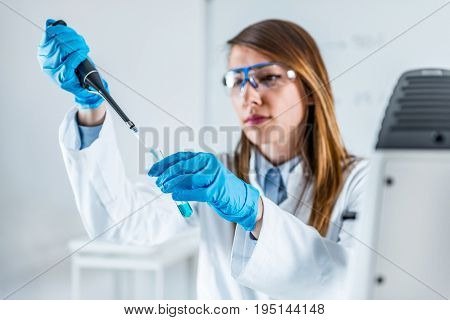 Laboratory Technician Using Micro Pipette, One Woman Only, Toned Image