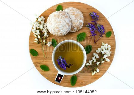 A Cup Of Herbal Tea And A Honey Cookies Covered With White Sugar Glaze On A Wooden Sand Board. Flowe