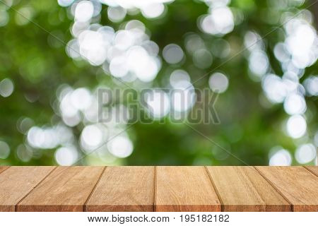 Empty wooden table top and sunny blurred bokeh background for product displa