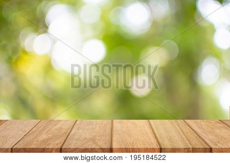 Empty wooden table top and sunny blurred bokeh background for product displa