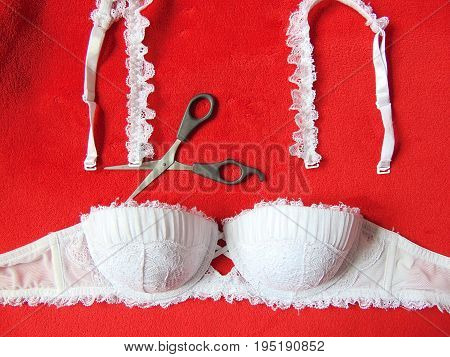 White lace strapless bra with scissors cutting the straps