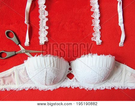 White lace strapless bra with scissors cutting the straps