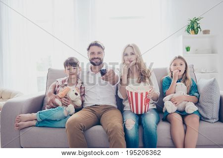 Fun Time Together. Happy Family Of Four Is Watching Interesting Educational Documentary, Eating Popc