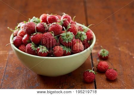 Bowl with fresh strawberry on wooden table