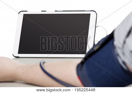 Electronic smart blood pressure monitor or sphygmomanometer with a phone or tablet hooked up to an inflatable arm cuff. This device is the modern version of the traditional medical instrument for health care.
