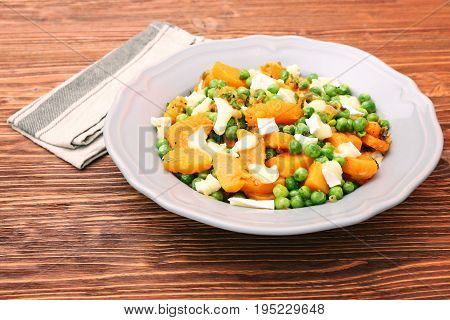 Warm salad with roasted pumpkin, peas and cheese brie. Low fat healthy eating concept.