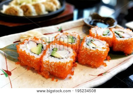 Ebiko maki sushi rolls - japanese food style in a ceramic plate.