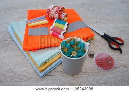 Sewing tools and sewing kit on wooden textured background. Sewing kit. Thread needles and cloth. tailor workspace with sewing and handmade tools