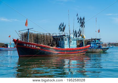 Hoi An, Vietnam - August 15, 2015: Vietnamese fishing boats on the Vin Cura Dai river, the mouth of the Thu Bon river near Hoi An in Vietnam.