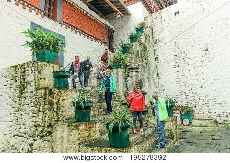 Trongsa Bhutan - September 12 2016: Happy tourist group standing on the stairs in the courtyard of Trongsa Dzong Bhutan
