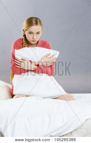 Sad Depressed Girl In Bed Gripping Pillow