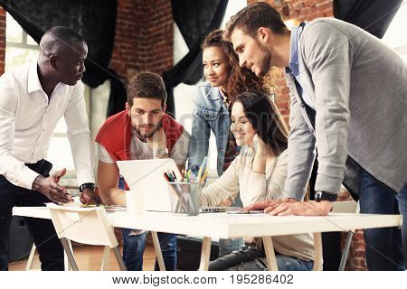 Teamwork concept.Young creative coworkers working with new startup project in modern office.Group of people analyze data on desktop computer.