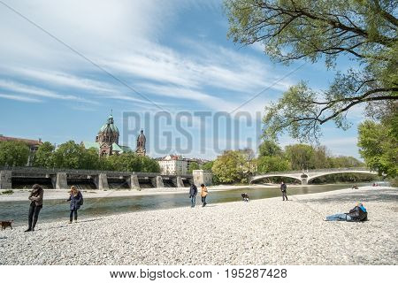 Munich, Germany - 21 April 2017 : View Of People Enjoy Sunny Day At The River Bank Of Isar River In