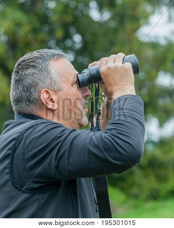 Romanian Hiker Enjoying The Retezat Mountains Through Binoculars In Romania