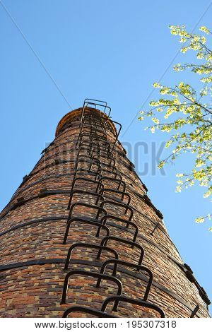 High industrial chimney view from below. Against the background of the sky