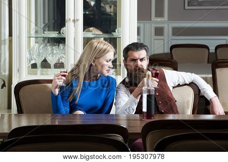 Couple In Love Sharing Bottle Of Wine In Restaurant