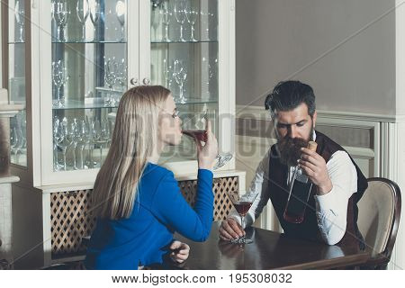 Man And Woman Sharing Bottle Of Red Wine In Restaurant