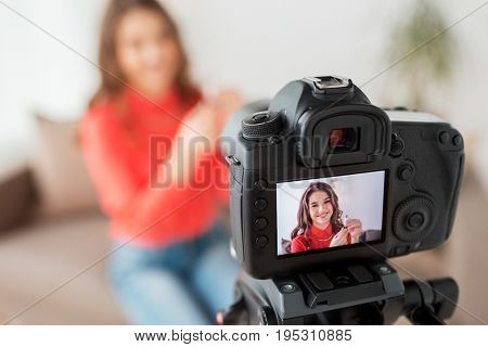 blogging, technology, videoblog, makeup and people concept - happy smiling woman or beauty blogger with lipstick and camera recording tutorial video at home