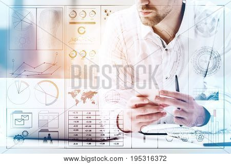 Handsome businessman at workplace using smartphone and using laptop. Toned image. Creative digital business hologram layer. Technology and communication concept. Double exposure