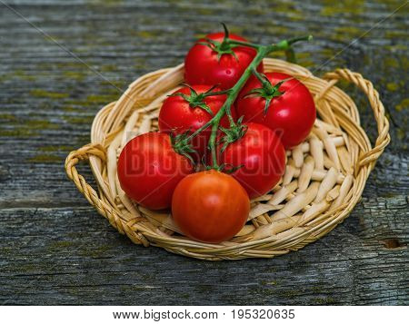 Bunch of fresh tomatoes and tomato juice in glass on wooden table