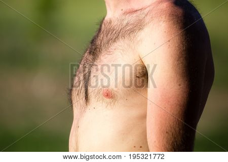 Hairy chest of a man in the open air .
