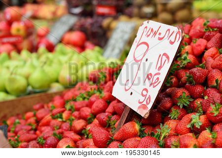 Mahane Yehuda Market in Jerusalem. Close up strawberries for sale written information: Strawberries 990 shekels