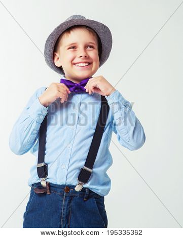 happy stylish boy wearing a hat and a tie, against white background