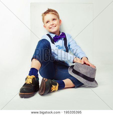 cheerful happy boy wearing a hat and tie, isolated against white