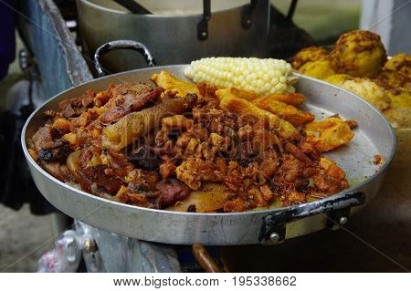 Close up of hornado roasted pork with a corn, ecuadorian traditional typical andean food over a tray .